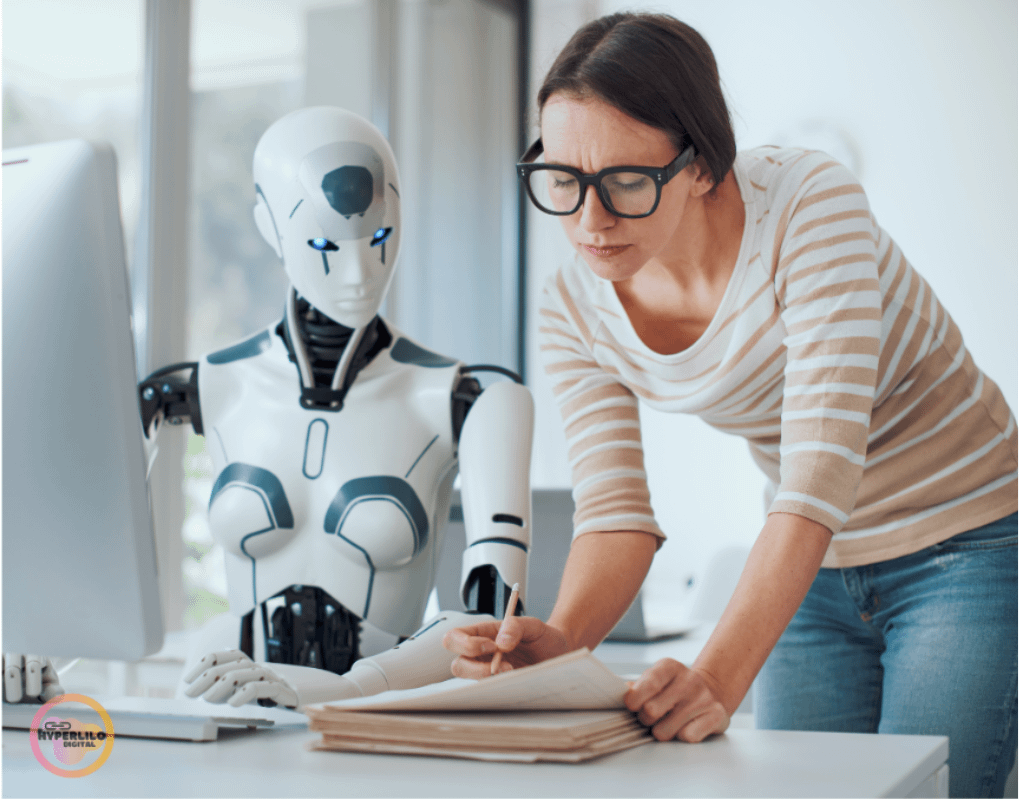 A robot sits at a computer as a woman writes on paper.